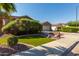 Attractive home featuring a lush green lawn, desert landscaping, and a partial driveway view at 13629 W San Miguel Ave, Litchfield Park, AZ 85340