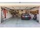 Well-organized garage featuring a sleek black convertible, ample storage, and tool organization at 13629 W San Miguel Ave, Litchfield Park, AZ 85340