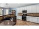 Modern kitchen with white cabinets, stainless steel appliances, and dark granite countertops at 13629 W San Miguel Ave, Litchfield Park, AZ 85340
