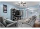 Comfortable living room with tile flooring, a ceiling fan, and a decorative TV console at 13629 W San Miguel Ave, Litchfield Park, AZ 85340