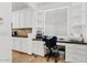 Office area with built-in shelves, cabinets, desk, and a large window for natural light at 13629 W San Miguel Ave, Litchfield Park, AZ 85340