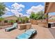 Inviting patio with lounge chairs, outdoor kitchen, and charming desert landscaping, perfect for relaxation at 13629 W San Miguel Ave, Litchfield Park, AZ 85340