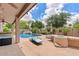 Stunning backyard featuring a refreshing pool, elegant lounge area, and outdoor kitchen for entertainment at 13629 W San Miguel Ave, Litchfield Park, AZ 85340
