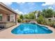 Inviting backyard pool with waterfall feature, lush landscaping, and blue sky at 13629 W San Miguel Ave, Litchfield Park, AZ 85340