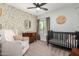 Charming Bedroom with floral wallpaper, a crib, comfy armchair, and natural light at 15038 N 22Nd St, Phoenix, AZ 85022