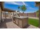 Backyard featuring an outdoor kitchen, covered patio, and lush artificial grass at 15038 N 22Nd St, Phoenix, AZ 85022