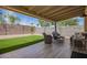 Covered patio with outdoor seating, artificial turf, and a privacy wall for relaxing outdoor living at 15038 N 22Nd St, Phoenix, AZ 85022
