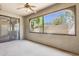 Enclosed patio with textured walls, ceiling fan, and a view of landscaped yard at 15252 N 100Th St # 1147, Scottsdale, AZ 85260