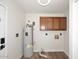 Functional laundry room with wood-look floors, storage cabinets, and a water heater at 15801 N 29Th N St # 20, Phoenix, AZ 85032