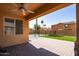 A cozy covered patio overlooks the backyard with a pool and turf at 16071 W Sherman St, Goodyear, AZ 85338