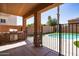 A covered patio overlooks the fenced pool, turf, and built-in barbeque at 16071 W Sherman St, Goodyear, AZ 85338