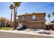 Two-story home with a three-car garage, tile roof, stone accents, and palm tree landscaping at 16071 W Sherman St, Goodyear, AZ 85338