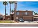 Charming two-story home featuring a tile roof, stone accents, and well-manicured landscaping with palm trees at 16071 W Sherman St, Goodyear, AZ 85338