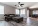 Comfortable living room featuring a brown sofa with an ottoman and a ceiling fan at 16071 W Sherman St, Goodyear, AZ 85338