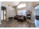 Spacious living room with a fireplace, large windows, hardwood floors, and neutral tones at 16071 W Sherman St, Goodyear, AZ 85338