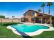 Beautiful backyard featuring a pool, artificial grass, and well-manicured palm trees at 16071 W Sherman St, Goodyear, AZ 85338