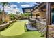 Backyard with putting green, outdoor kitchen and beautiful lush plants at 16141 N 183Rd Dr, Surprise, AZ 85388