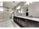 A luxurious bathroom with double sinks, granite countertops, and a walk-in shower with elegant tile at 16141 N 183Rd Dr, Surprise, AZ 85388