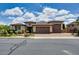 Charming single-story home featuring a three-car garage, desert landscaping, and a brick driveway at 16141 N 183Rd Dr, Surprise, AZ 85388