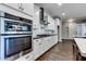 Gourmet kitchen with built-in stainless appliances, tile backsplash, sleek countertops, and wood-look tile flooring at 16141 N 183Rd Dr, Surprise, AZ 85388