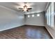 Spacious living room with wood-look tile floors, a ceiling fan, and plenty of natural light from the windows at 16141 N 183Rd Dr, Surprise, AZ 85388