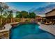 Stunning backyard showcasing a pool with a waterfall feature, fire accents, and an outdoor seating area at 16141 N 183Rd Dr, Surprise, AZ 85388