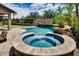 Inviting backyard oasis featuring a sparkling pool with a spa, rock waterfall, and lush landscaping at 16141 N 183Rd Dr, Surprise, AZ 85388