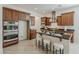 Spacious kitchen with dark wood cabinets, stainless steel appliances, and breakfast bar with stool seating at 16158 W Coronado Rd, Goodyear, AZ 85395