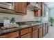 This modern kitchen features a gas cooktop with stainless steel range hood and dark countertops and wooden cabinets at 16158 W Coronado Rd, Goodyear, AZ 85395