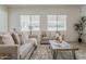Bright living room with neutral decor, large windows, and comfortable seating arrangement at 16158 W Coronado Rd, Goodyear, AZ 85395
