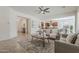 Spacious living room with open flow to the kitchen, featuring neutral decor and tile flooring at 16158 W Coronado Rd, Goodyear, AZ 85395