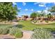 Community playground in a well-maintained park, surrounded by lush greenery and walking paths at 16158 W Coronado Rd, Goodyear, AZ 85395