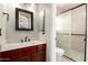 Bathroom with vanity, framed mirror and tiled stand-up shower with clear glass sliding door at 1634 E Harwell Rd, Phoenix, AZ 85042