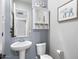 Charming powder room with pedestal sink, storage cabinet, and lovely elephant-themed decor at 18577 W Coolidge St, Goodyear, AZ 85395