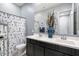 Bathroom with a large vanity, dual sinks, and decorative mirror complemented by a flower-themed shower curtain at 18577 W Coolidge St, Goodyear, AZ 85395