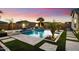 A stunning pool featuring a waterfall, travertine deck, and lush landscaping at 18577 W Coolidge St, Goodyear, AZ 85395