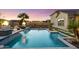 Sparkling pool featuring a waterfall feature, tiled trim and fire bowls for ambiance and a tropical feel at 18577 W Coolidge St, Goodyear, AZ 85395