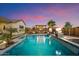 Resort-style backyard featuring a pool with a waterfall, fire features, and covered patio area at 18577 W Coolidge St, Goodyear, AZ 85395