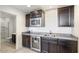 Granite countertop wet bar with mini-fridge, sink, microwave and storage cabinets at 18577 W Coolidge St, Goodyear, AZ 85395