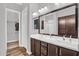 Bathroom featuring double sinks, brown cabinets, and a large framed mirror at 21104 E Poco Calle --, Queen Creek, AZ 85142