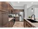 Kitchen with stainless appliances, dark wood cabinetry, and granite countertops at 21104 E Poco Calle --, Queen Creek, AZ 85142