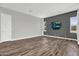 A spacious living room featuring wood-look floors, a TV, and plenty of natural light at 21104 E Poco Calle --, Queen Creek, AZ 85142