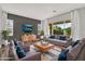 Spacious living room with wood floors, large windows, a modern TV, and gray accent walls at 21104 E Poco Calle --, Queen Creek, AZ 85142