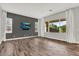 Bright living room with wood-look floors, large windows, a gray accent wall and white trim at 21104 E Poco Calle --, Queen Creek, AZ 85142