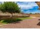 The well-kept backyard is landscaped with stone and artificial turf and includes a low retaining wall at 22040 N 119Th Dr, Sun City, AZ 85373
