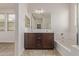 Bright bathroom with double vanity, soaking tub, and glass-enclosed shower at 22040 N 119Th Dr, Sun City, AZ 85373
