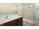 Clean bathroom featuring a shower with glass doors and wood cabinets at 22040 N 119Th Dr, Sun City, AZ 85373