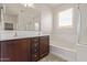 Bright bathroom features a double vanity, a tub, and a separate shower with a glass door at 22040 N 119Th Dr, Sun City, AZ 85373