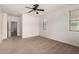 Comfortable bedroom with neutral carpet, ceiling fan, and a bright window at 22040 N 119Th Dr, Sun City, AZ 85373