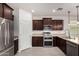 Stylish kitchen features stainless steel appliances and dark wood cabinets at 22040 N 119Th Dr, Sun City, AZ 85373